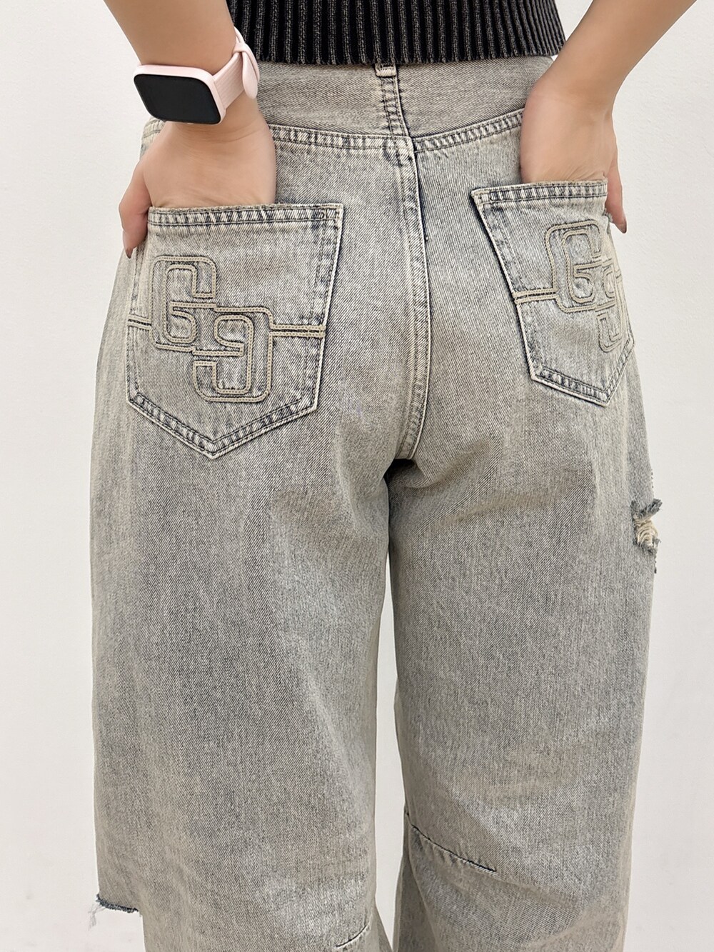 ブラック系のニット/セーター、ブルー系のデニムパンツ、ブラック系のバックパック/リュックを着用したレディースの夏コーディネートの8枚目の写真