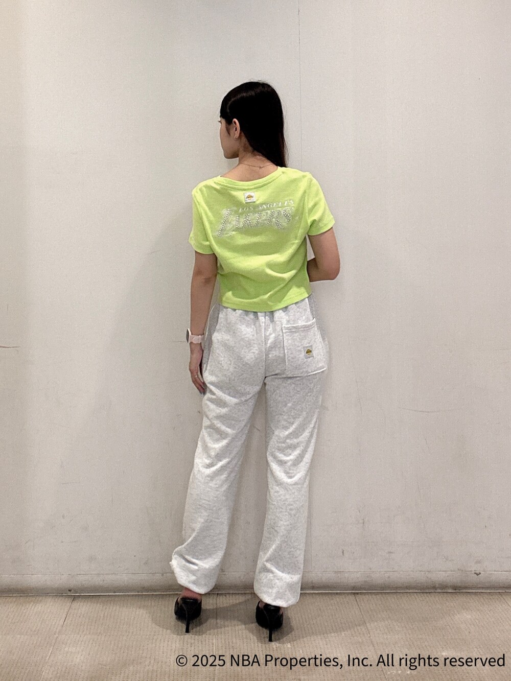 グリーン系のTシャツ/カットソー、グレー系のスウェットパンツ、ブラック系のパンプスを着用したレディースの夏コーディネートの3枚目の写真