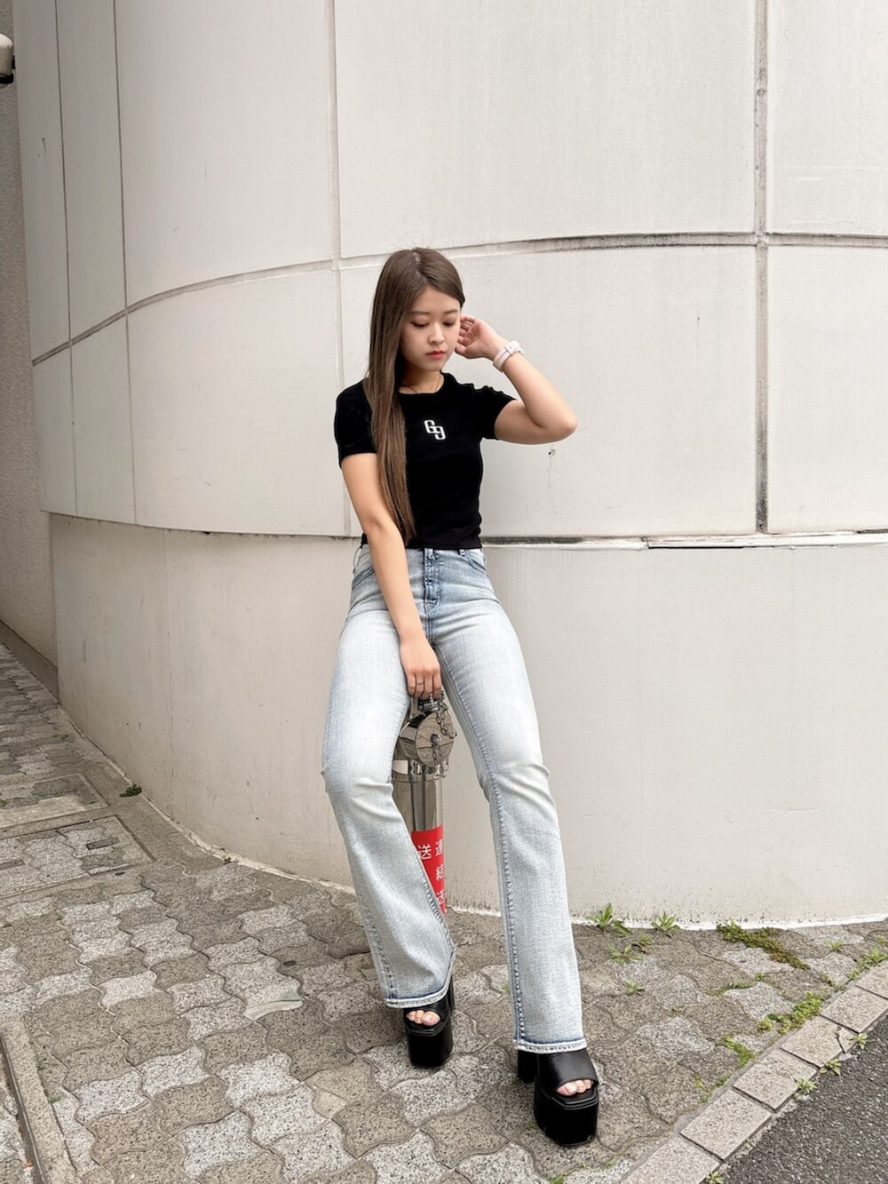 ブラック系のサンダル、ブラック系のTシャツ/カットソー、ブルー系のデニムパンツを着用したレディースの春コーディネートの5枚目の写真