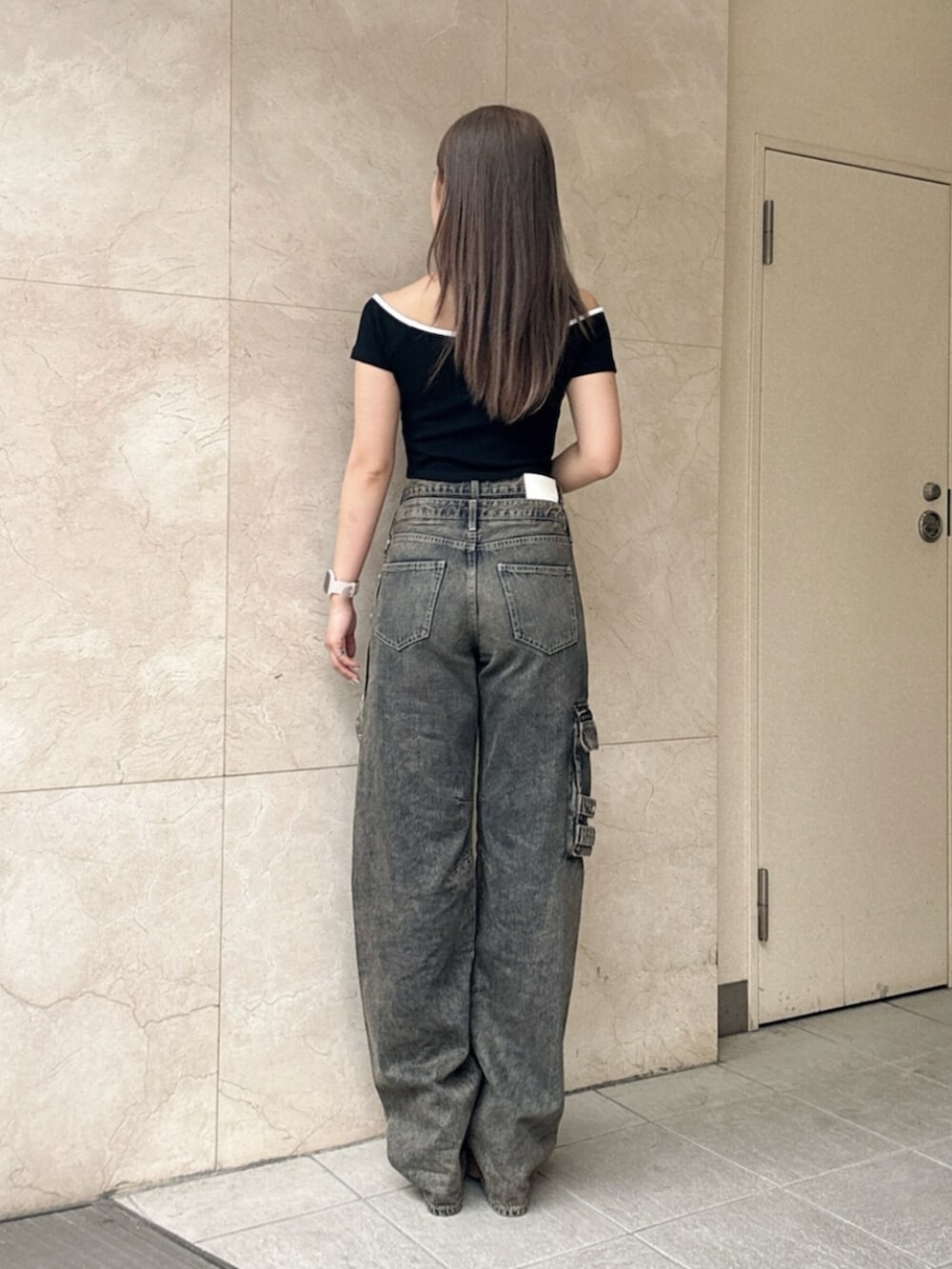 ブルー系のデニムパンツ、ブラック系のサンダル、ブラック系のTシャツ/カットソーを着用したレディースの夏コーディネートの3枚目の写真