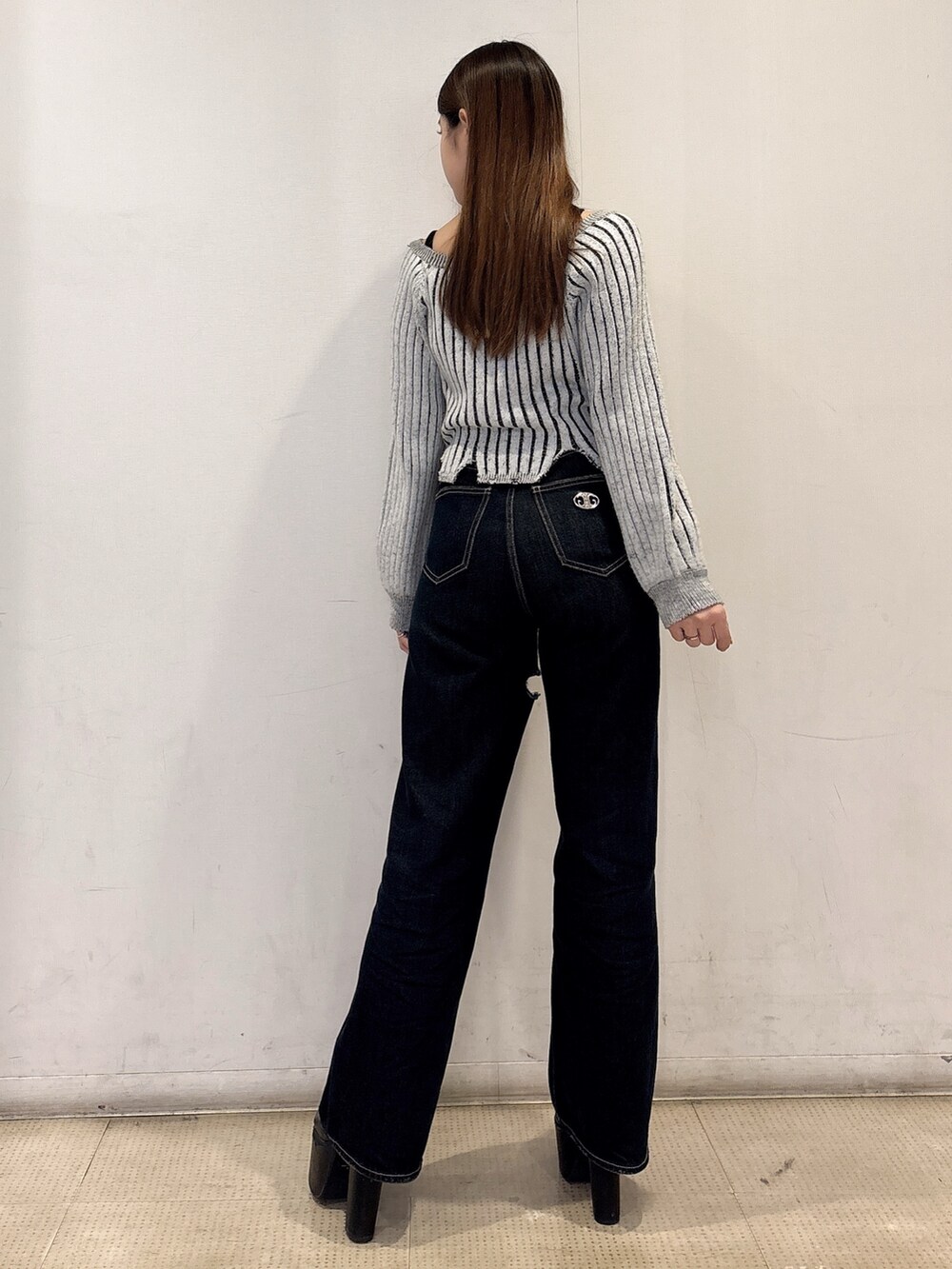 ブラック系のニット/セーター、ブルー系のデニムパンツ、ブラック系のブーツを着用したレディースの冬コーディネートの3枚目の写真