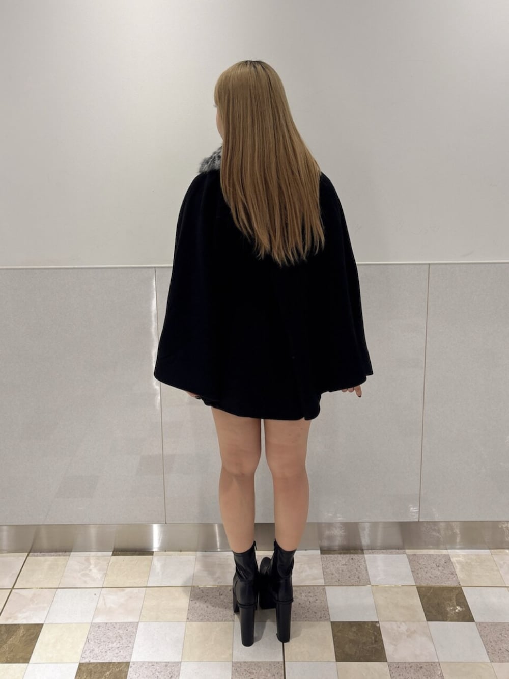ブラック系のブーツ、ブラック系のTシャツ/カットソー、ブルー系のデニムスカートを着用したレディースの秋コーディネートの3枚目の写真