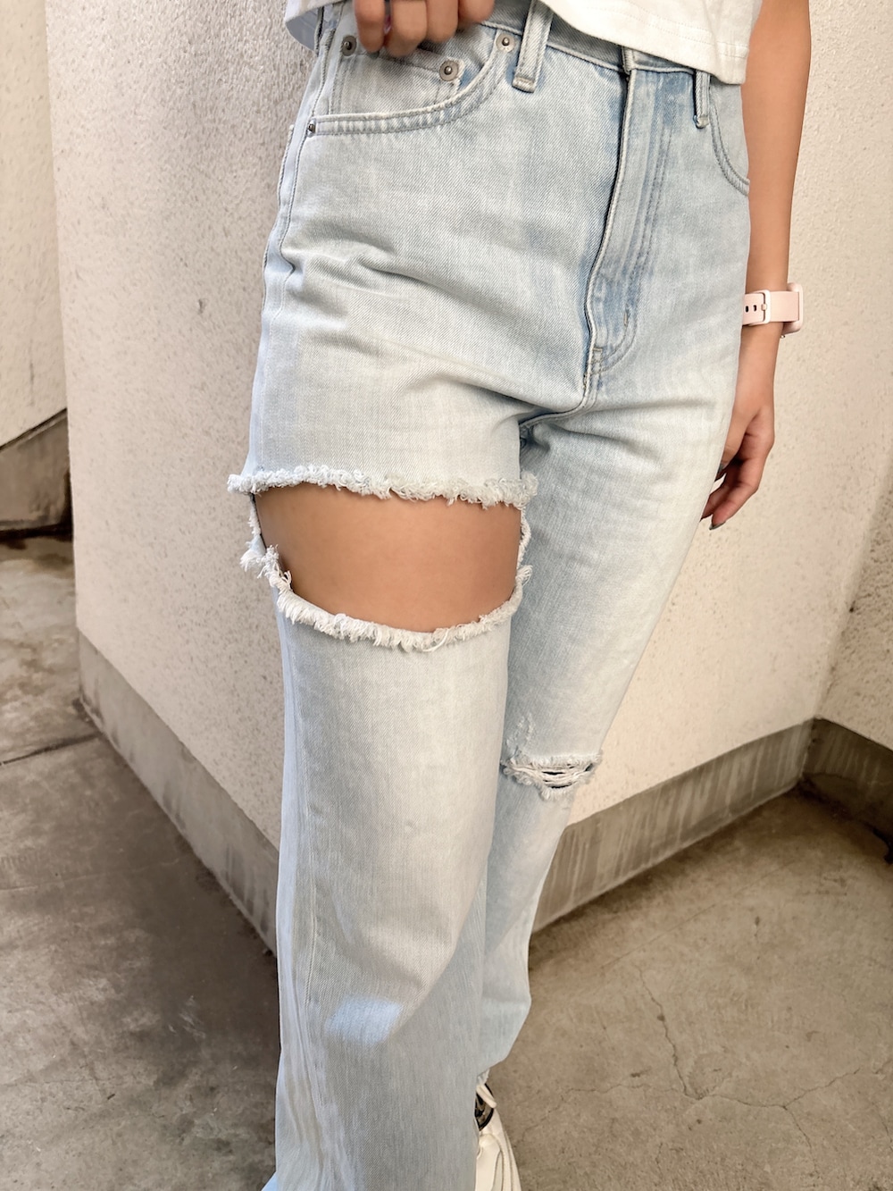 ホワイト系のTシャツ/カットソー、ブルー系のデニムパンツ、ホワイト系のスニーカーを着用したレディースの春コーディネートの6枚目の写真