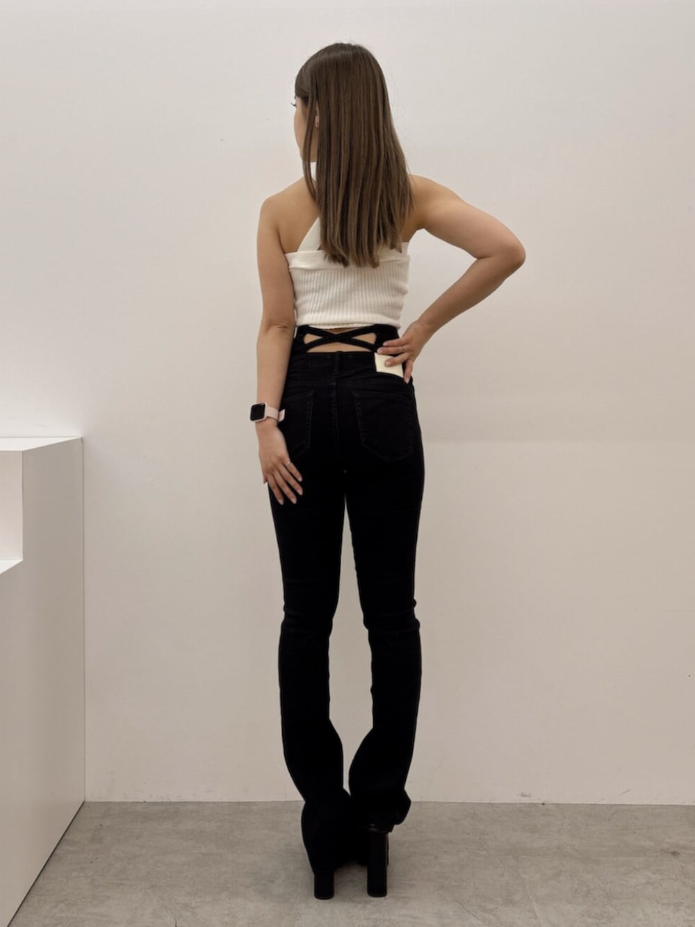 ブラック系のサンダル、ホワイト系のタンクトップ、ブラック系のデニムパンツを着用したレディースの春コーディネートの3枚目の写真