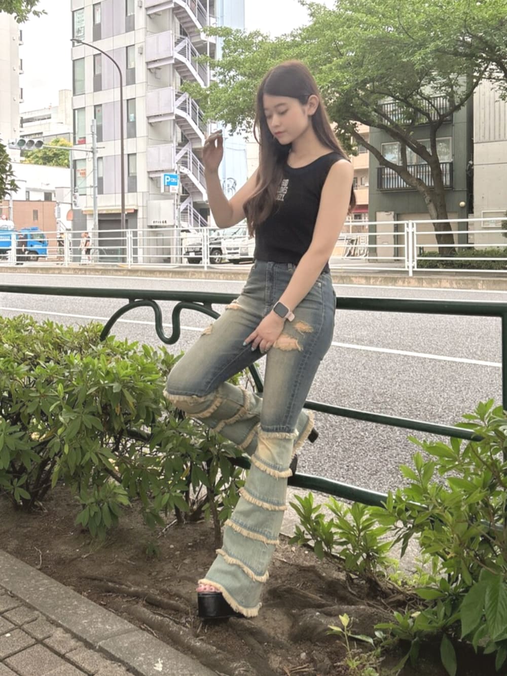 ブラック系のサンダル、ブラック系のタンクトップ、ブルー系のデニムパンツを着用したレディースの夏コーディネートの7枚目の写真