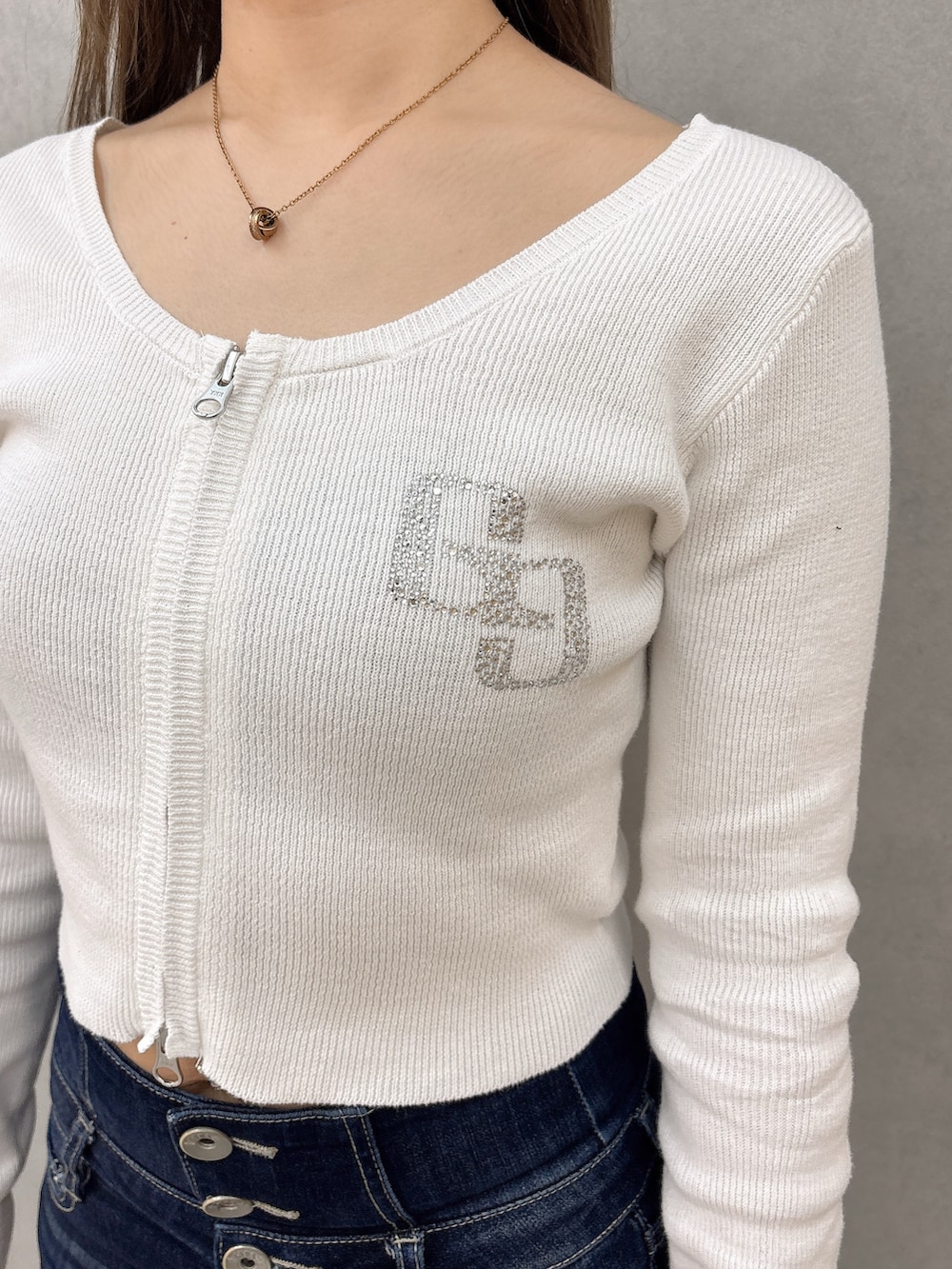 ホワイト系のニット/セーター、ブルー系のデニムパンツ、ブラック系のパンプスを着用したレディースの春コーディネートの5枚目の写真