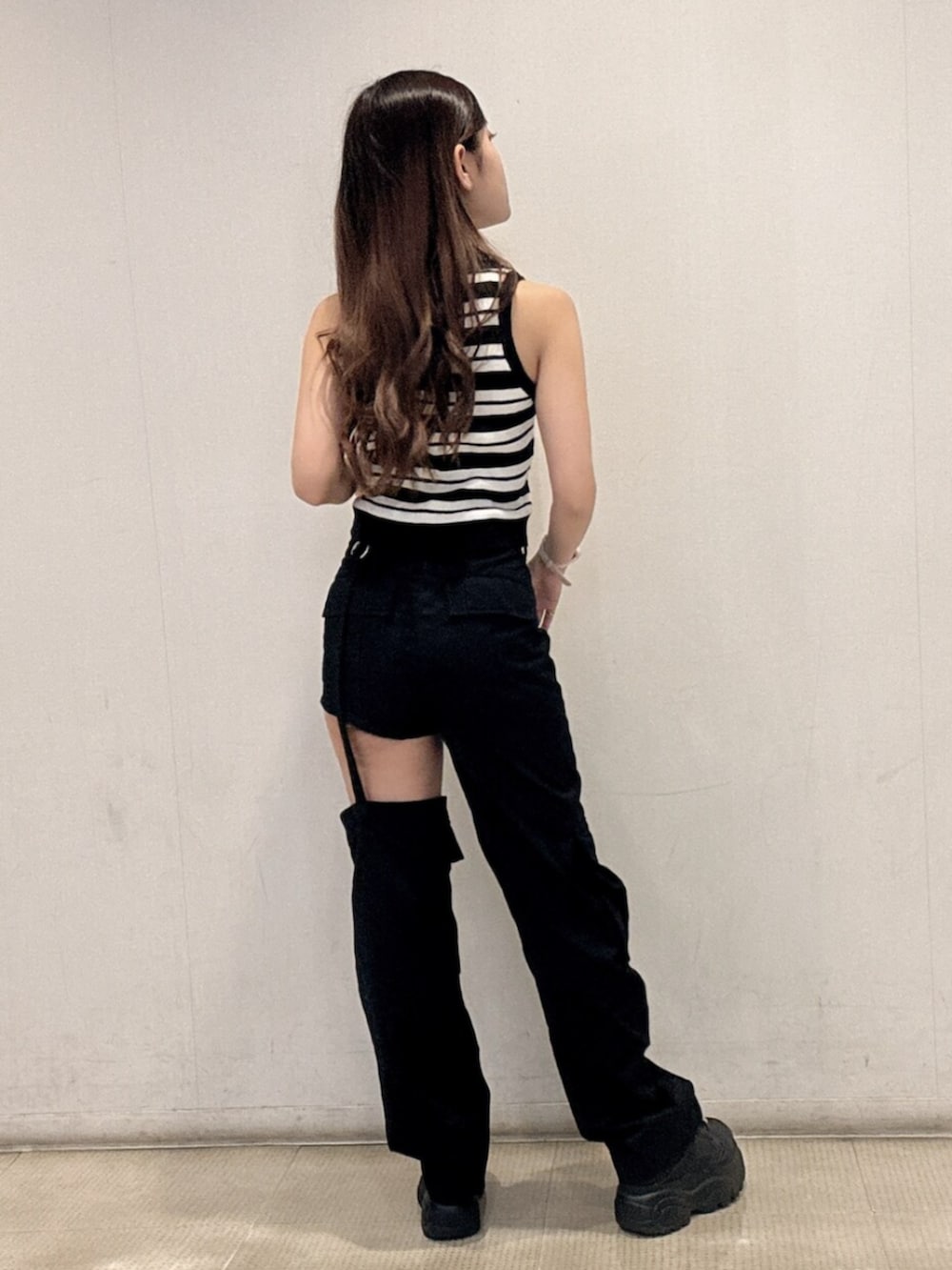 ブラック系のスニーカー、ホワイト系のニット/セーター、ブラック系のその他パンツを着用したレディースの春コーディネートの3枚目の写真