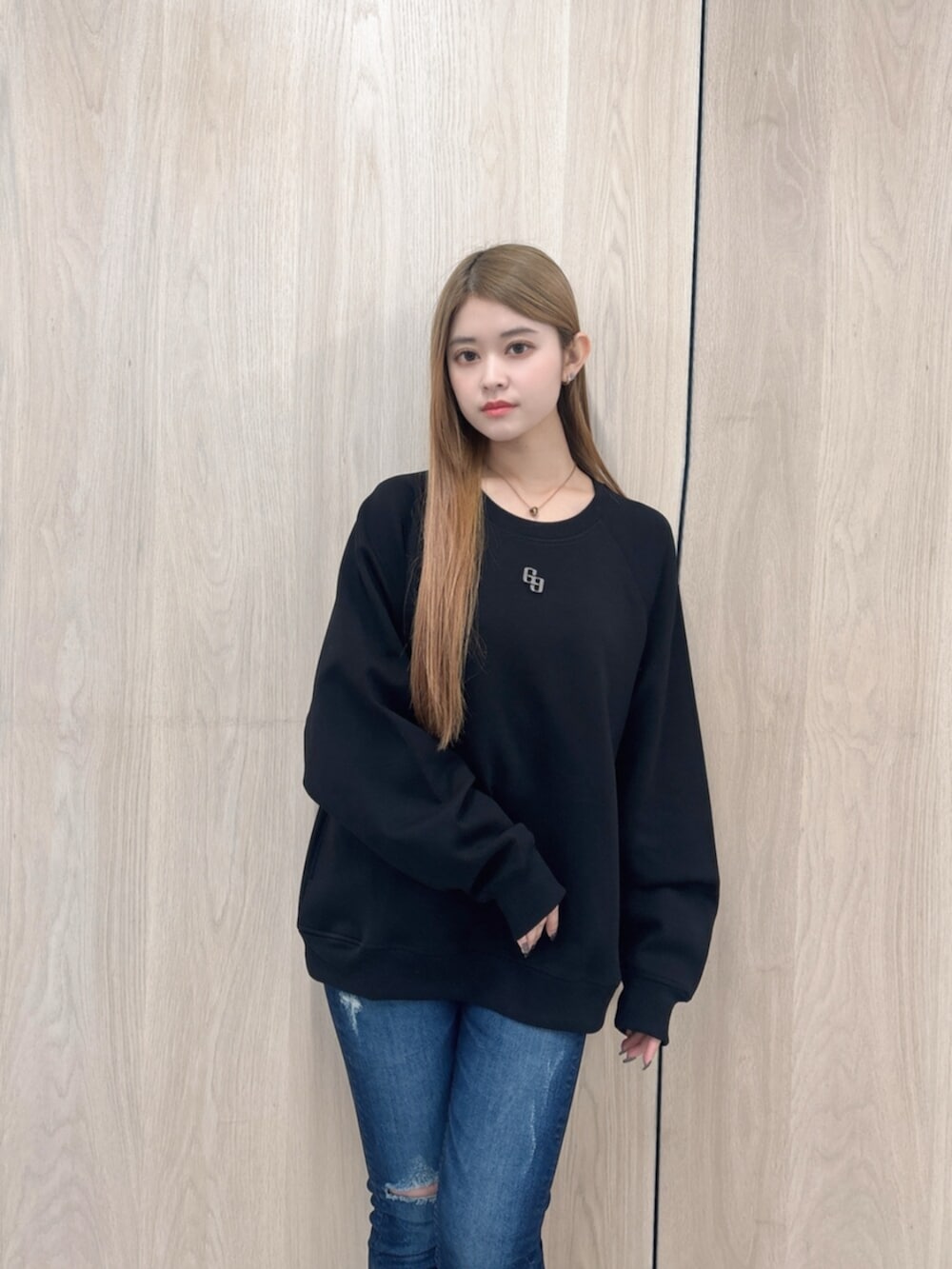 ブルー系のデニムパンツ、ブラック系のブーツ、ブラック系のスウェットを着用したレディースの春コーディネートの4枚目の写真