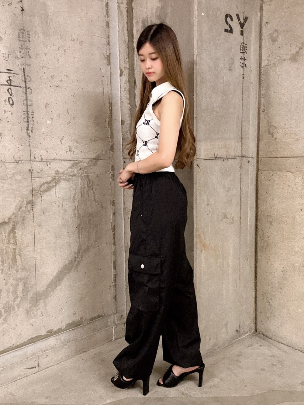 ホワイト系のニット/セーター、ブラック系のその他パンツ、ブラック系のサンダルを着用したレディースの春コーディネートの2枚目の写真