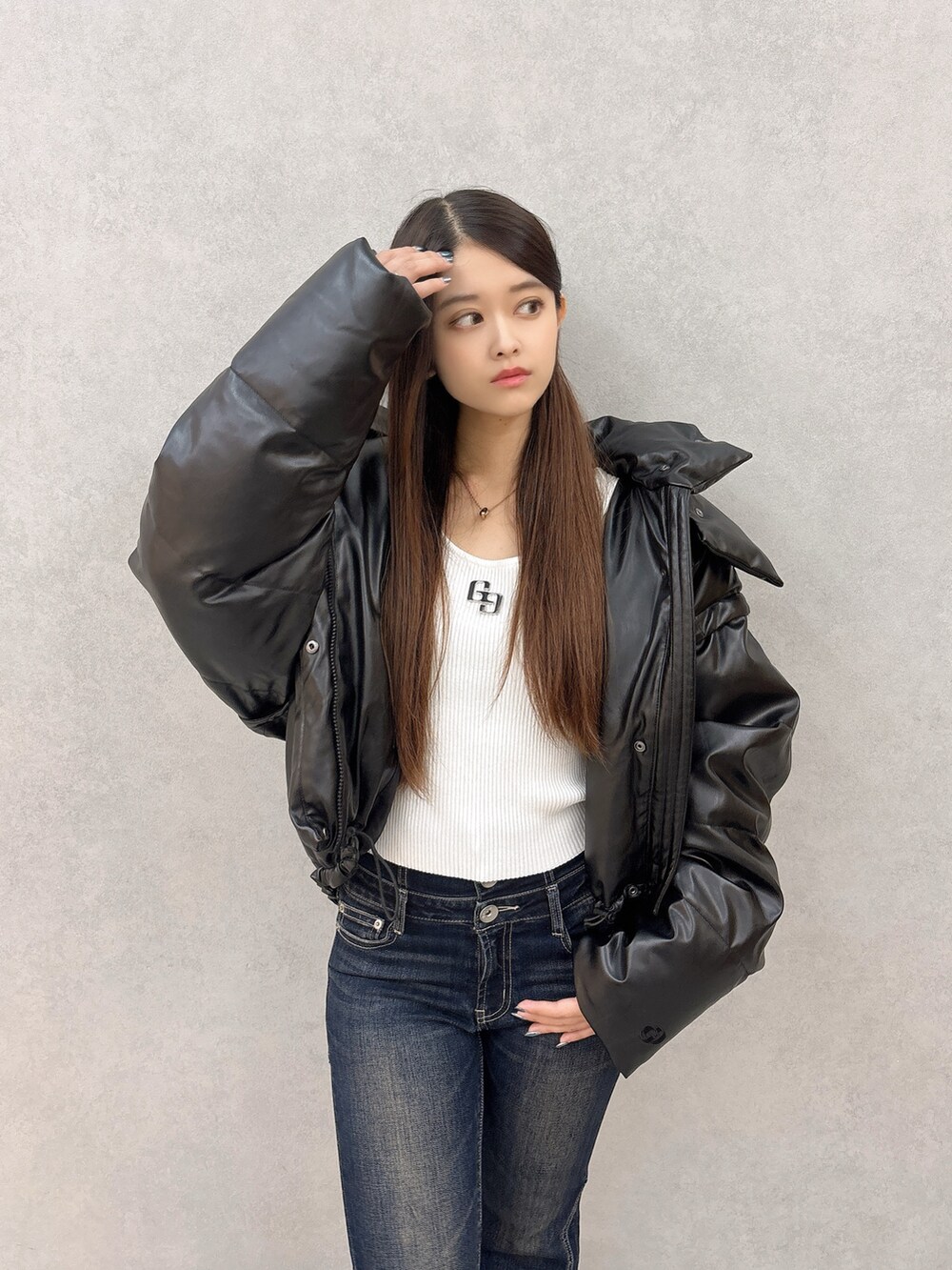 ホワイト系のニット/セーター、ブラック系のダウンジャケット/コート、ブラック系のブーツを着用したレディースの秋コーディネートの4枚目の写真