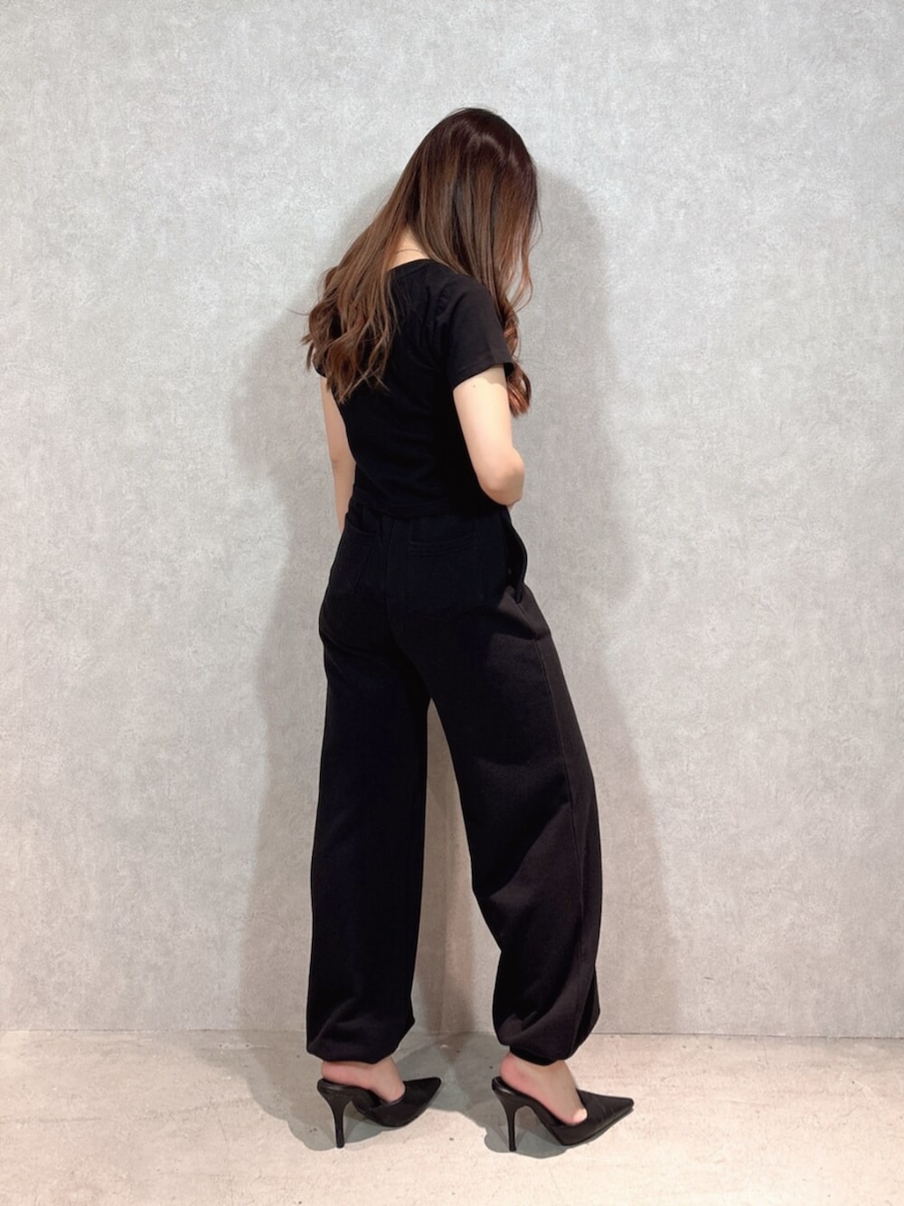 ブラック系のパンプス、ブラック系のTシャツ/カットソー、ブラック系のスウェットパンツを着用したレディースの春コーディネートの2枚目の写真