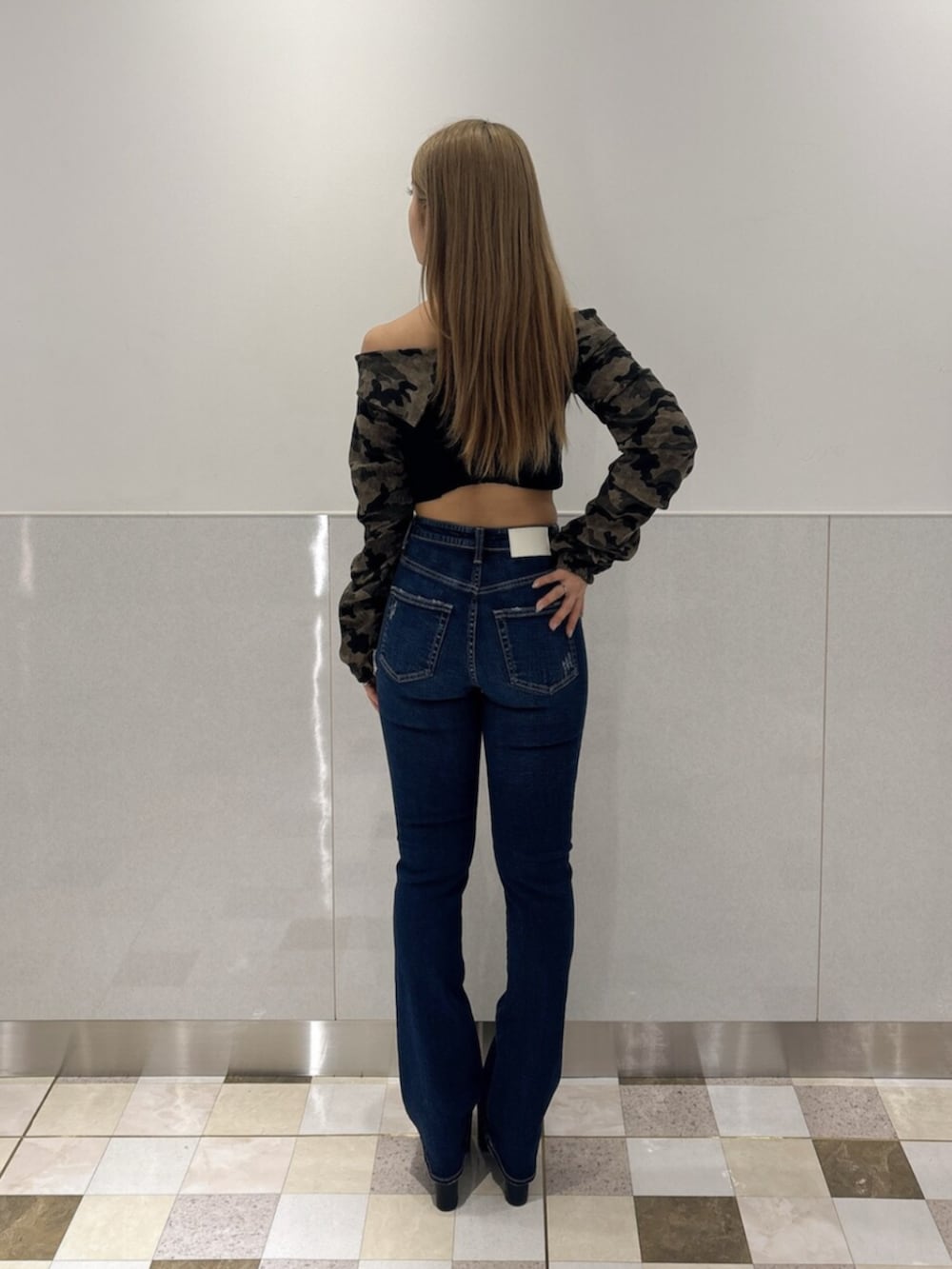 ブルー系のデニムパンツ、ブラック系のブーツ、グリーン系のTシャツ/カットソーを着用したレディースの秋コーディネートの3枚目の写真