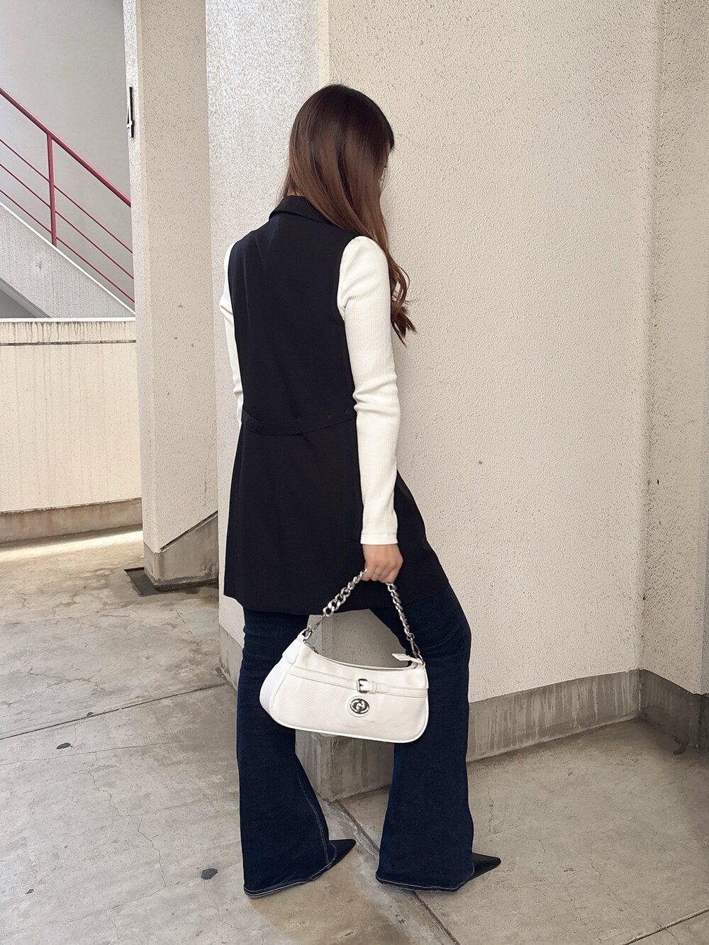 ホワイト系のTシャツ/カットソー、ブラック系のベスト、ブルー系のデニムパンツを着用したレディースの春コーディネートの2枚目の写真