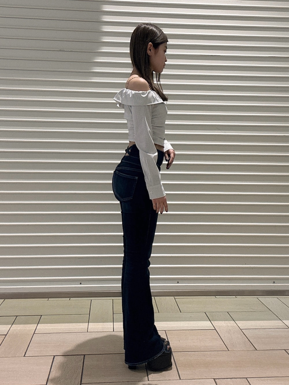 ホワイト系のシャツ/ブラウス、ブルー系のデニムパンツ、ブラック系のサンダルを着用したレディースの春コーディネートの2枚目の写真