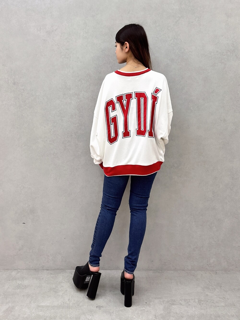 ホワイト系のスウェット、ブルー系のデニムパンツ、ブラック系のサンダルを着用したレディースの夏コーディネートの3枚目の写真