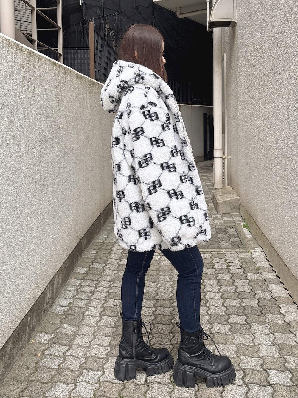 ブルー系のニット/セーター、ブルー系のデニムパンツ、ホワイト系のブルゾンを着用したレディースの秋コーディネートの2枚目の写真