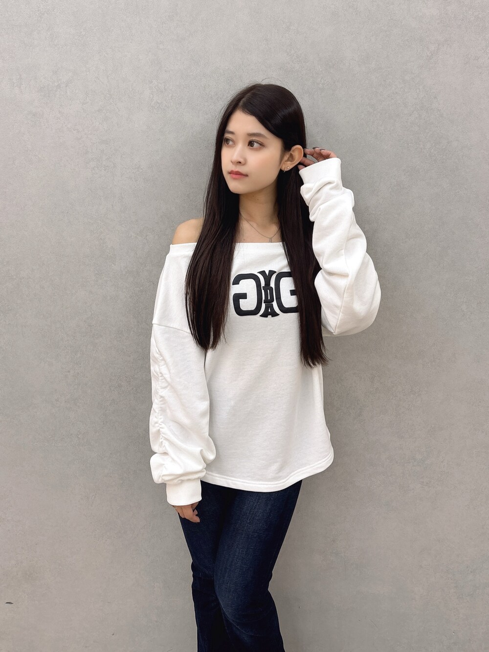 ホワイト系のスウェット、ブルー系のデニムパンツ、ブラック系のブーツを着用したレディースの秋コーディネートの4枚目の写真