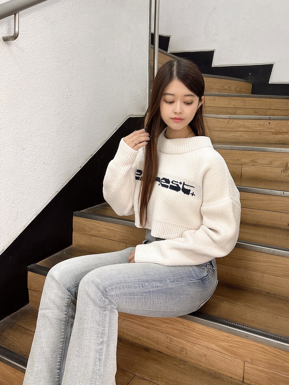 ホワイト系のニット/セーター、ブルー系のデニムパンツ、ブラック系のブーツを着用したレディースの秋コーディネートの5枚目の写真