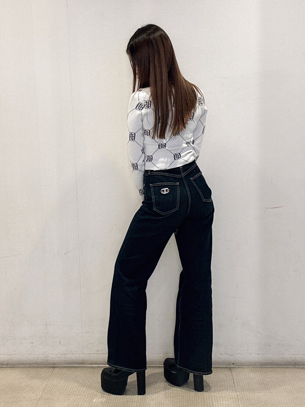 ホワイト系のニット/セーター、ブルー系のデニムパンツ、ブラック系のブーツを着用したレディースの冬コーディネートの2枚目の写真