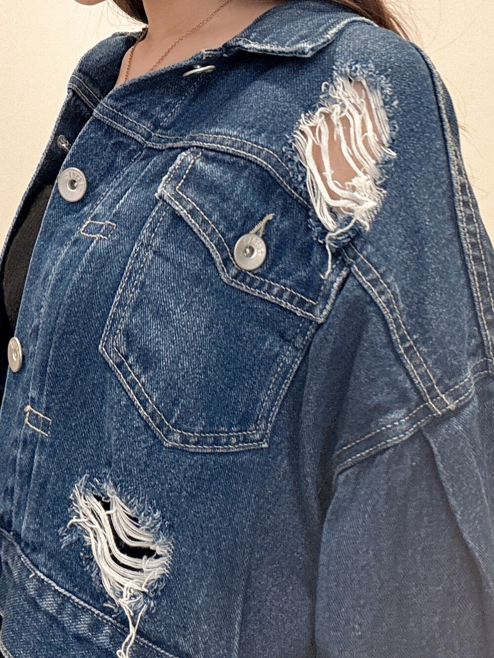 ブラック系のワンピース、ブルー系のデニムジャケット、ブラック系のパンプスを着用したレディースの春コーディネートの5枚目の写真