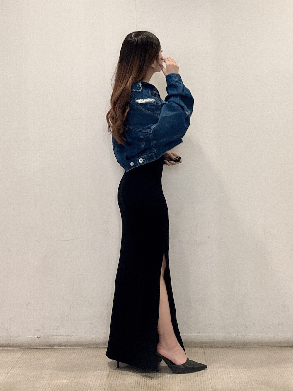 ブラック系のワンピース、ブルー系のデニムジャケット、ブラック系のパンプスを着用したレディースの春コーディネートの3枚目の写真