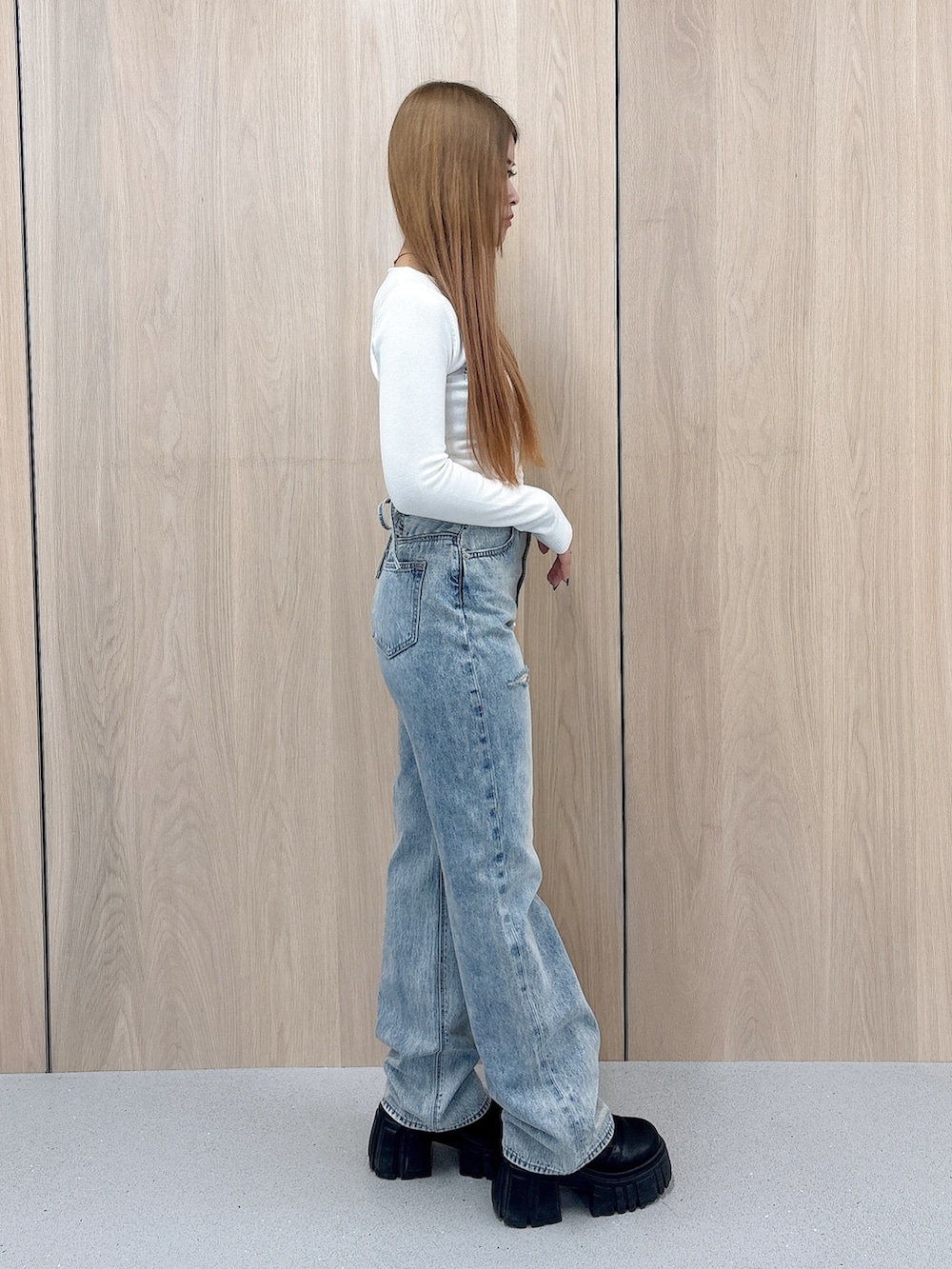 ホワイト系のニット/セーター、ブルー系のデニムパンツ、ブラック系のブーツを着用したレディースの春コーディネートの2枚目の写真