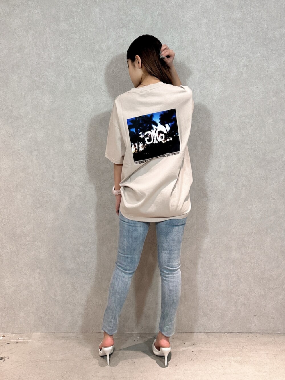 ベージュ系のTシャツ/カットソー、ブルー系のデニムパンツ、ホワイト系のパンプスを着用したレディースの春コーディネートの3枚目の写真