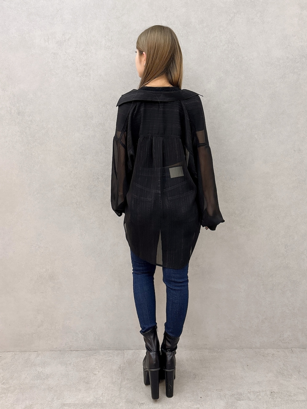 ブラック系のシャツ/ブラウス、ブラック系のTシャツ/カットソー、ブルー系のデニムパンツを着用したレディースの冬コーディネートの3枚目の写真