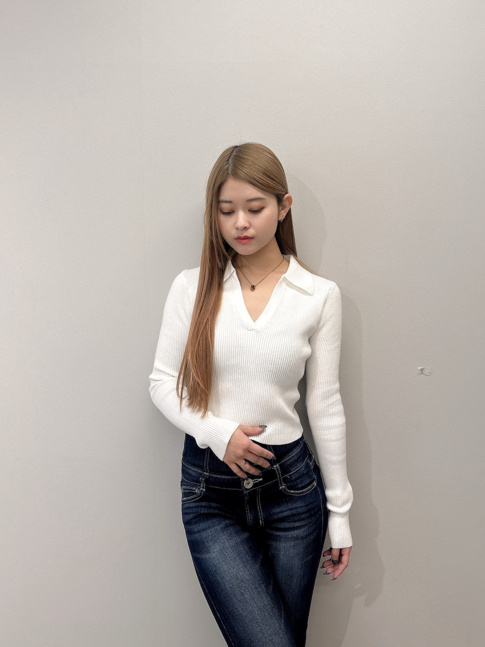 ホワイト系のニット/セーター、ブルー系のデニムパンツ、ブラック系のブーツを着用したレディースの春コーディネートの4枚目の写真