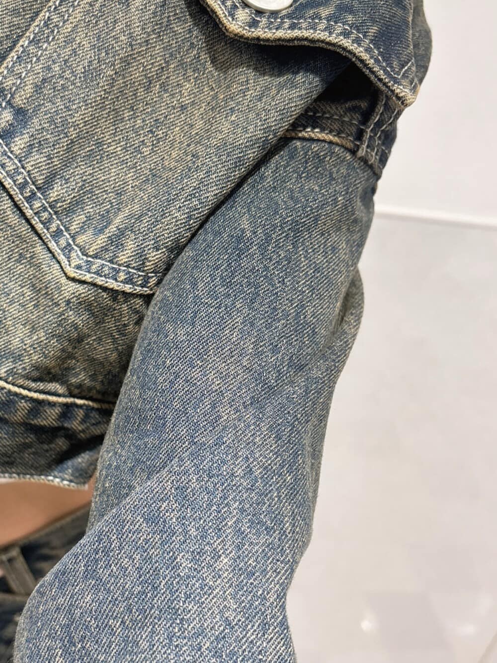 ホワイト系のタンクトップ、ブルー系のデニムジャケット、ブルー系のデニムパンツを着用したレディースの夏コーディネートの6枚目の写真
