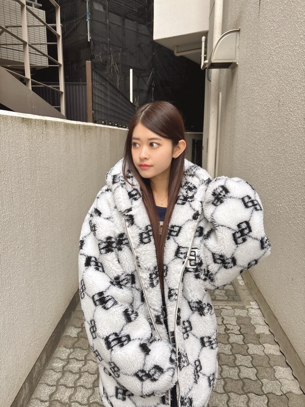 ブルー系のニット/セーター、ブルー系のデニムパンツ、ホワイト系のブルゾンを着用したレディースの秋コーディネートの4枚目の写真