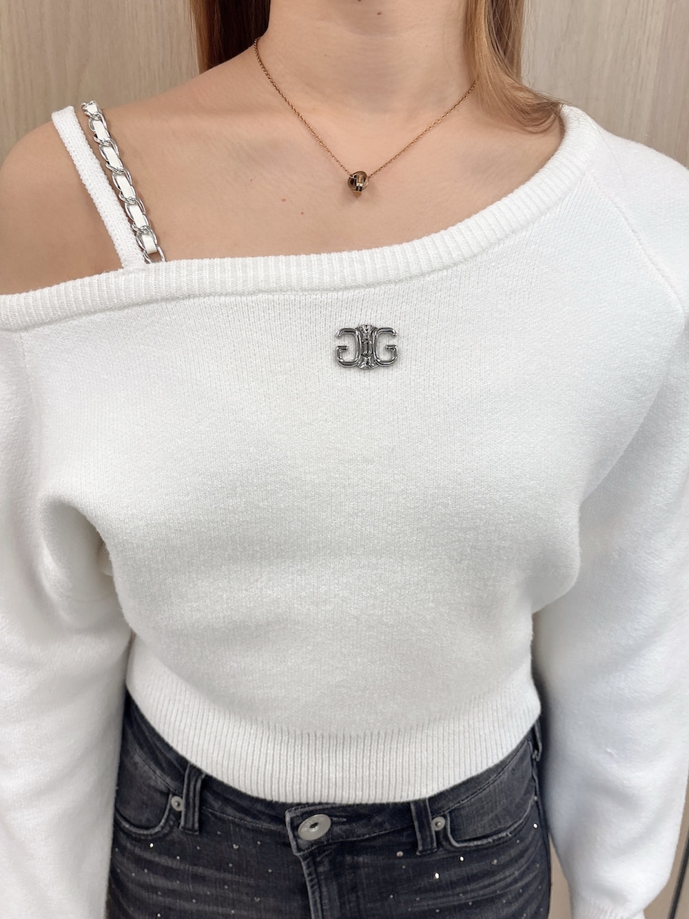 ホワイト系のニット/セーター、ブラック系のデニムパンツ、ブラック系のブーツを着用したレディースの冬コーディネートの5枚目の写真