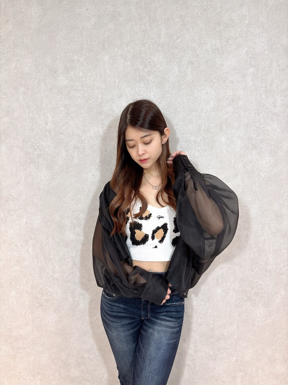 ベージュ系のキャミソール、ブラック系のシャツ/ブラウス、ブルー系のデニムパンツを着用したレディースの春コーディネートの4枚目の写真