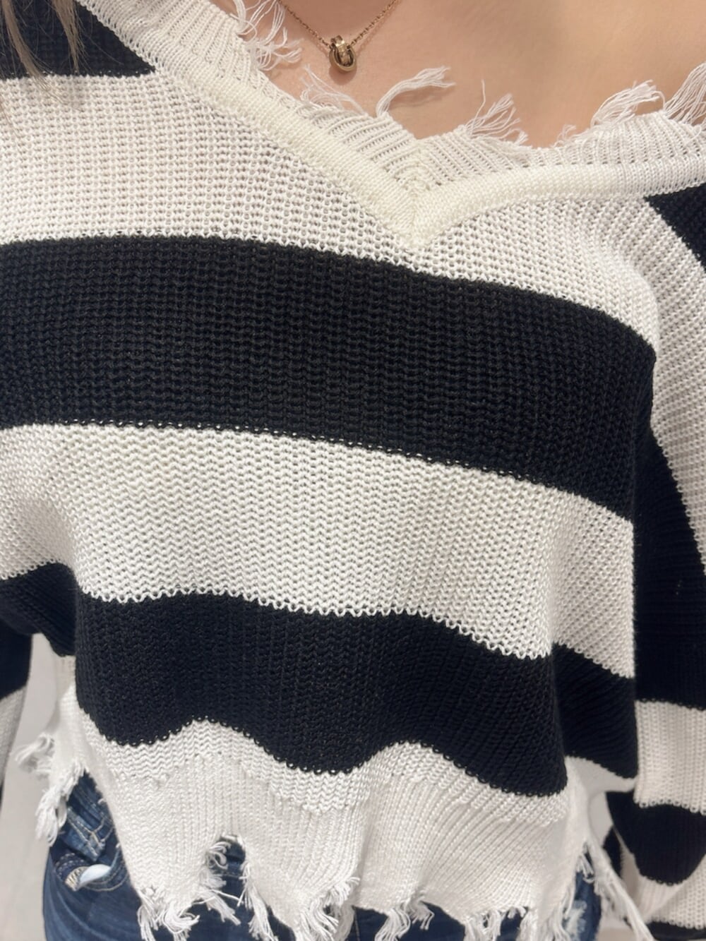 ブラック系のサンダル、ブルー系のデニムパンツ、ブラック系のニット/セーターを着用したレディースの夏コーディネートの6枚目の写真