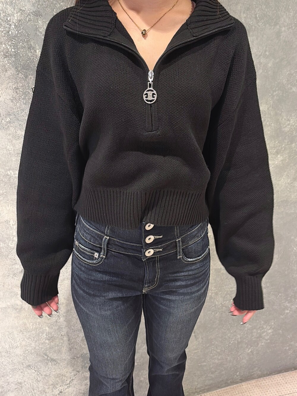 ブラック系のニット/セーター、ブルー系のデニムパンツ、ブラック系のブーツを着用したレディースの冬コーディネートの4枚目の写真