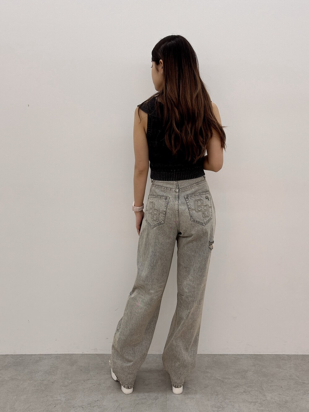 ブラック系のニット/セーター、ブルー系のデニムパンツ、ブラック系のバックパック/リュックを着用したレディースの夏コーディネートの4枚目の写真