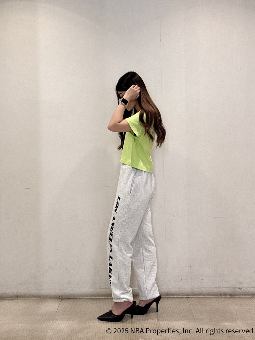 グリーン系のTシャツ/カットソー、グレー系のスウェットパンツ、ブラック系のパンプスを着用したレディースの夏コーディネートの2枚目の写真