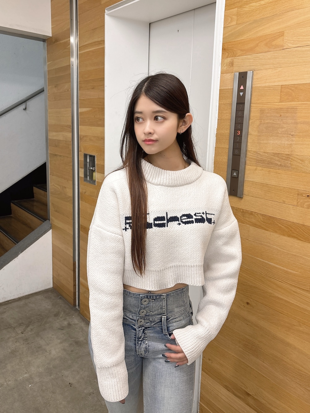 ホワイト系のニット/セーター、ブルー系のデニムパンツ、ブラック系のブーツを着用したレディースの秋コーディネートの4枚目の写真