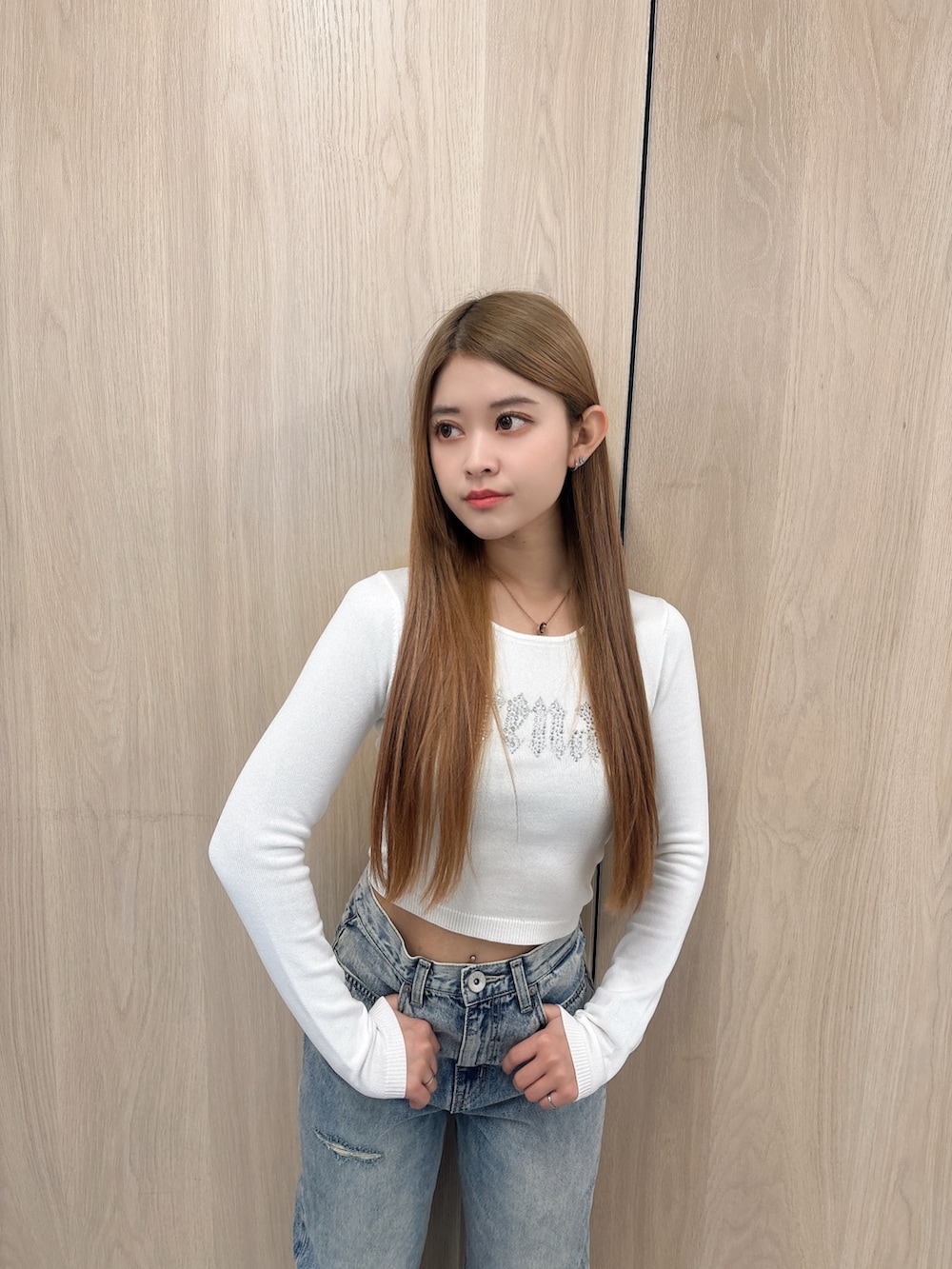 ホワイト系のニット/セーター、ブルー系のデニムパンツ、ブラック系のブーツを着用したレディースの春コーディネートの4枚目の写真