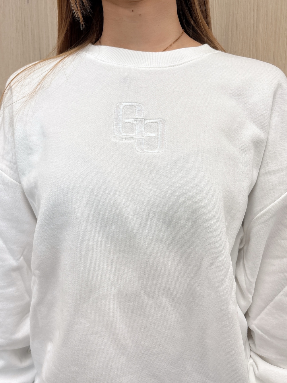 ホワイト系のパーカー、ブルー系のデニムパンツ、ブラック系のブーツを着用したレディースの春コーディネートの6枚目の写真