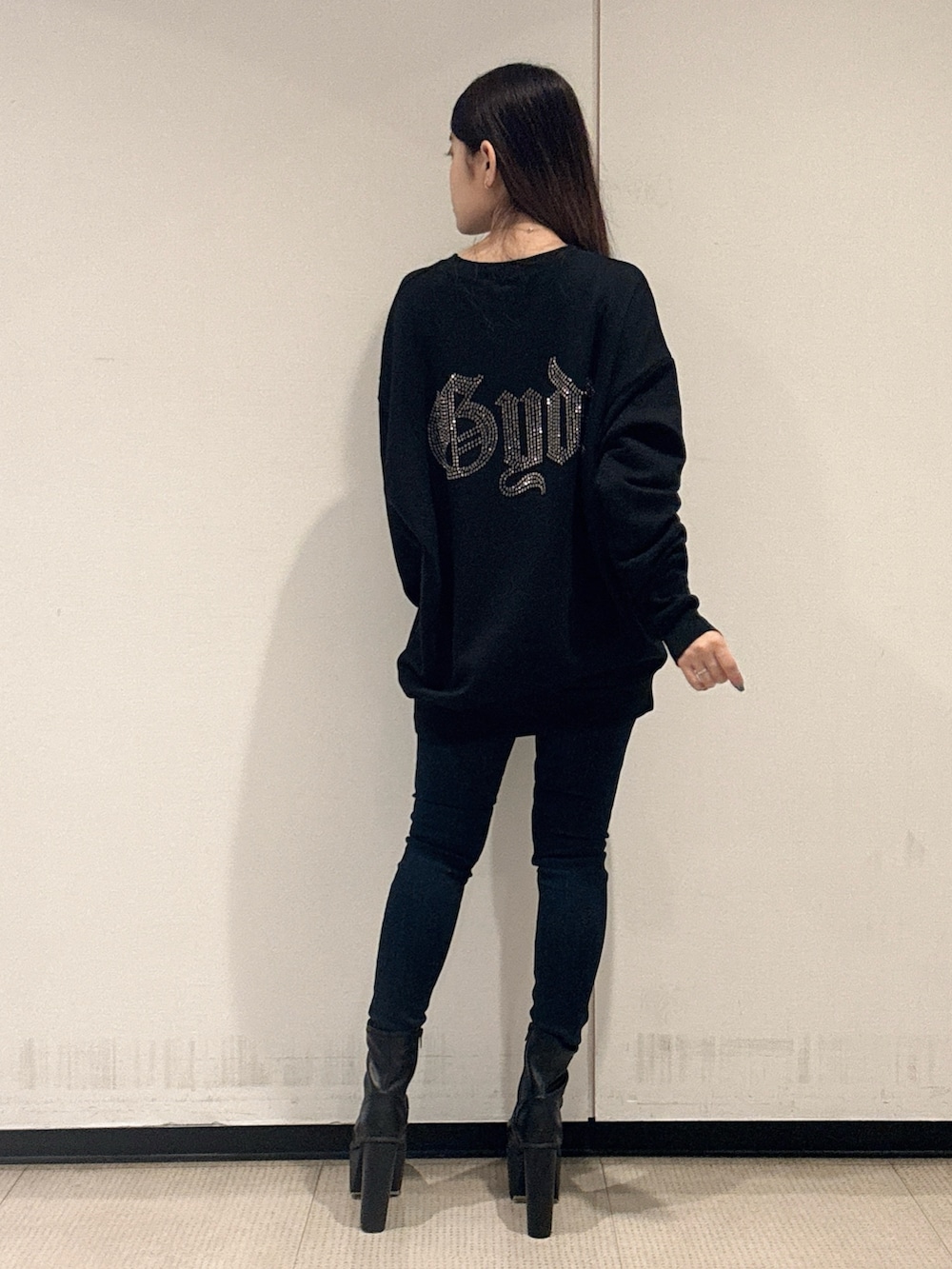 ブラック系のパーカー、ブルー系のデニムパンツ、ブラック系のブーツを着用したレディースの秋コーディネートの3枚目の写真