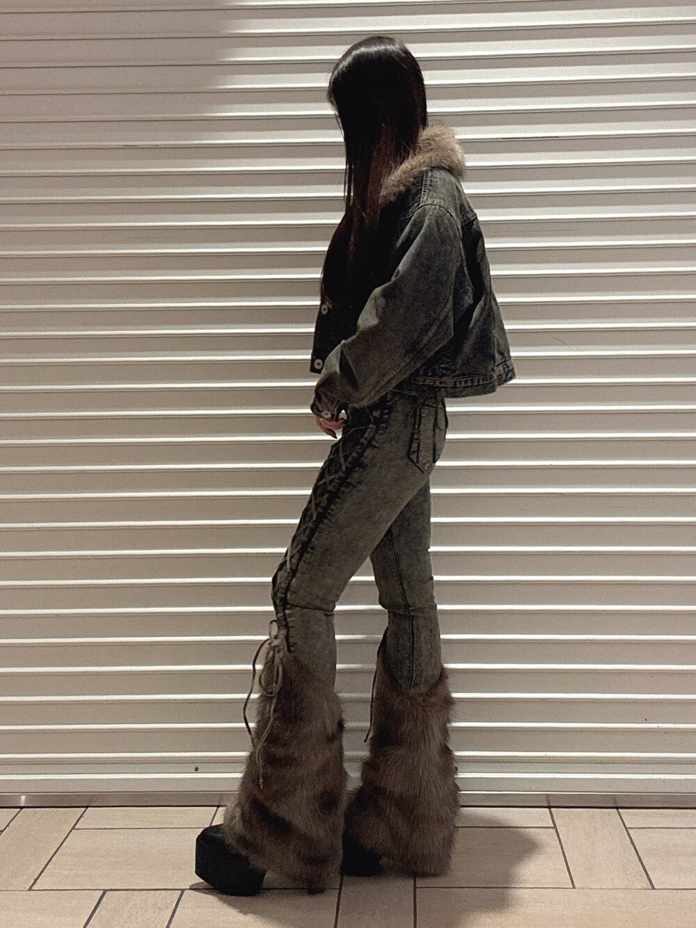 ブラック系のニット/セーター、ブルー系のデニムパンツ、ブルー系のデニムジャケットを着用したレディースの秋コーディネートの3枚目の写真