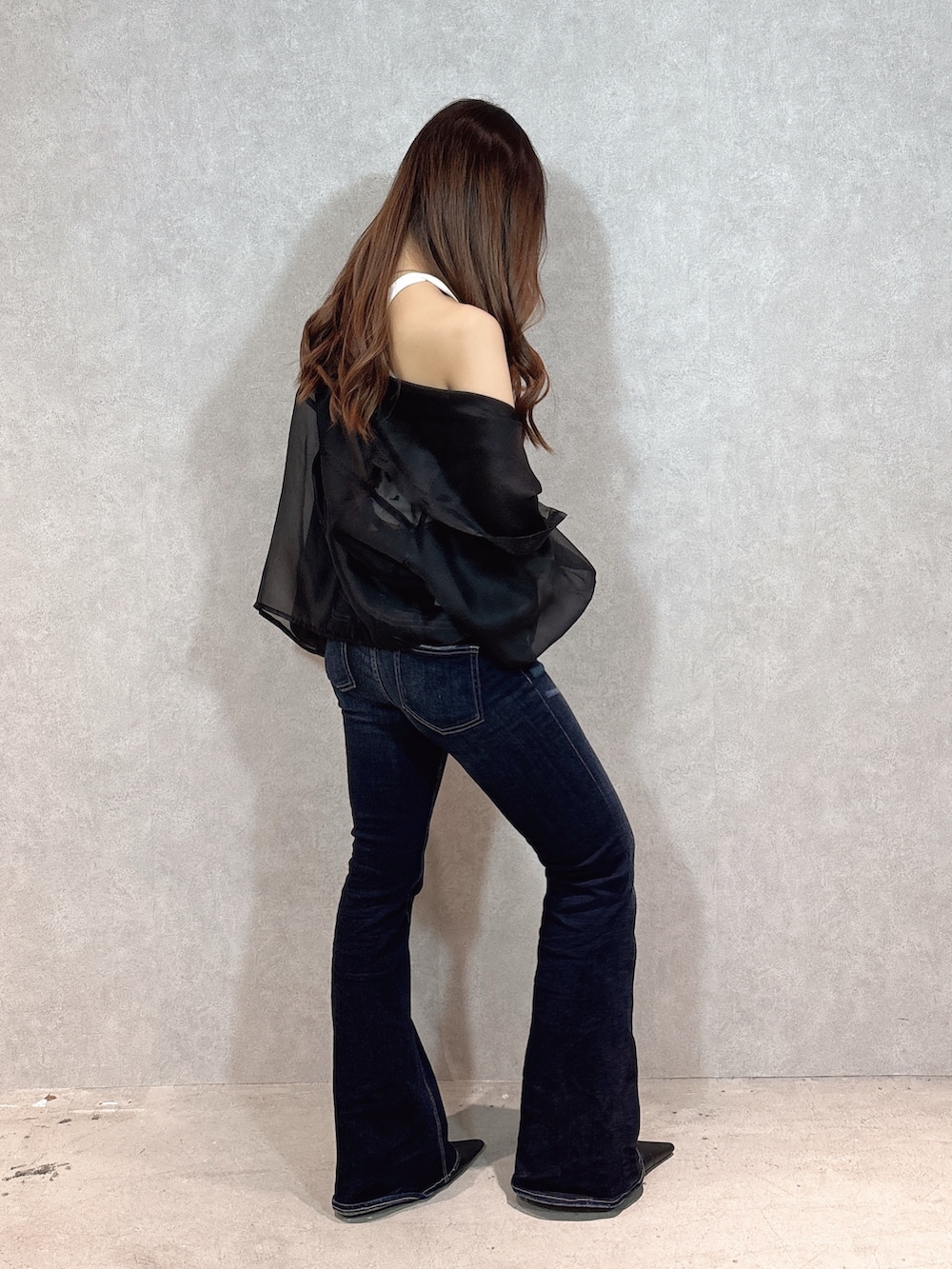 ベージュ系のキャミソール、ブラック系のシャツ/ブラウス、ブルー系のデニムパンツを着用したレディースの春コーディネートの2枚目の写真