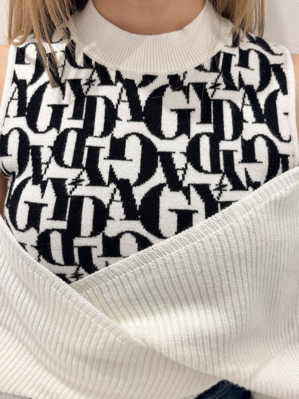 ブラック系のブーツ、ホワイト系のニット/セーター、ブルー系のデニムパンツを着用したレディースの秋コーディネートの5枚目の写真