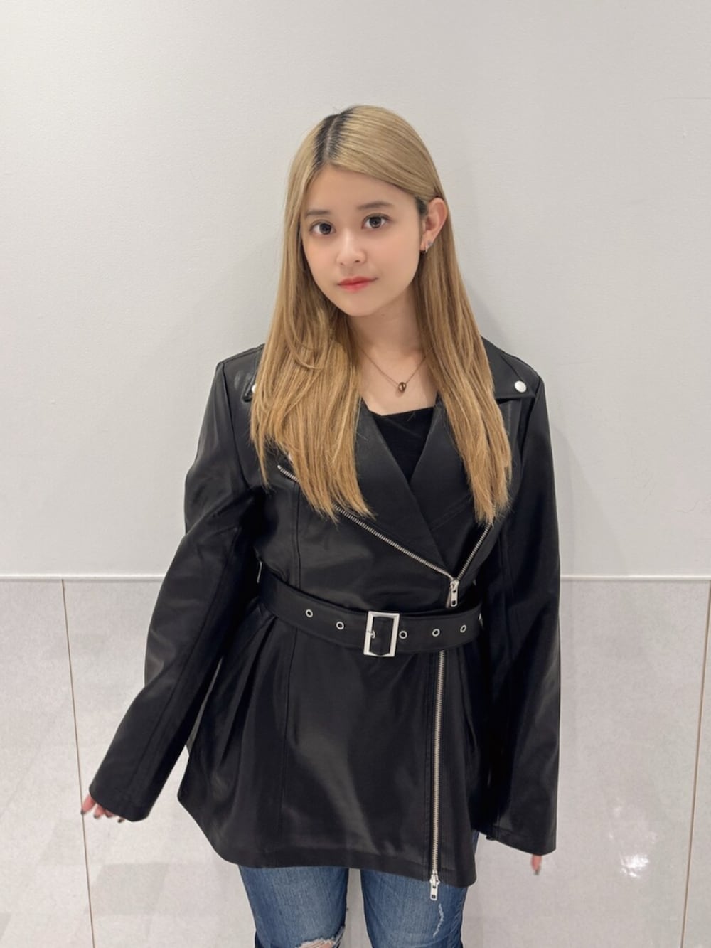 ブルー系のデニムパンツ、ブラック系のブーツ、ブラック系のTシャツ/カットソーを着用したレディースの秋コーディネートの4枚目の写真