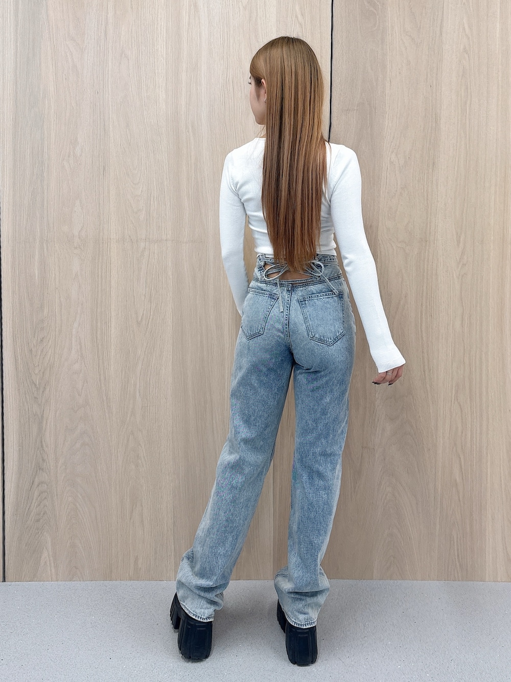 ホワイト系のニット/セーター、ブルー系のデニムパンツ、ブラック系のブーツを着用したレディースの春コーディネートの3枚目の写真