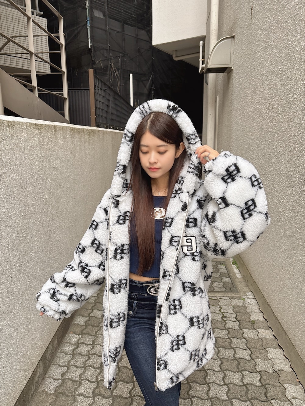 ブルー系のニット/セーター、ブルー系のデニムパンツ、ホワイト系のブルゾンを着用したレディースの秋コーディネートの5枚目の写真