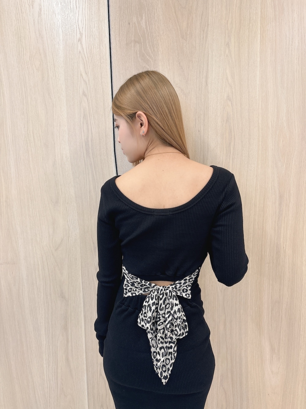 ブラック系のワンピース、ブラック系のブーツを着用したレディースの春コーディネートの5枚目の写真