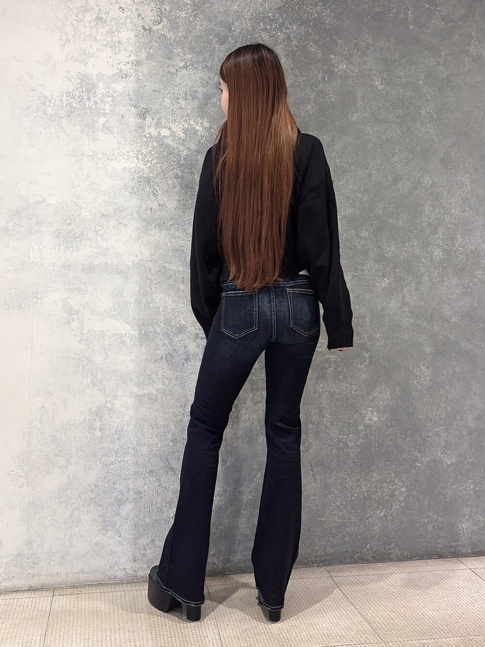 ブラック系のニット/セーター、ブルー系のデニムパンツ、ブラック系のブーツを着用したレディースの冬コーディネートの3枚目の写真