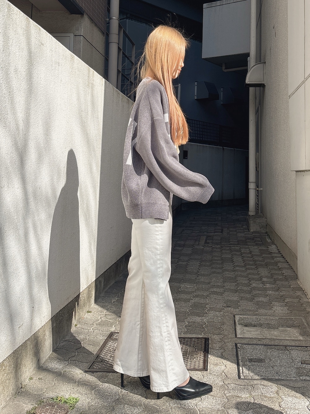 ホワイト系のつなぎ/オールインワン、グレー系のカーディガン/ボレロ、ブラック系のパンプスを着用したレディースの冬コーディネートの2枚目の写真